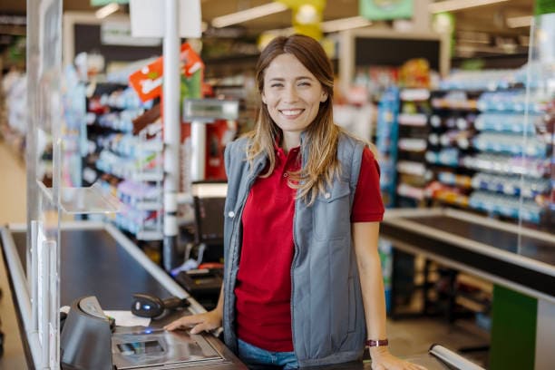 Une femme qui est devant une caisse magasin.