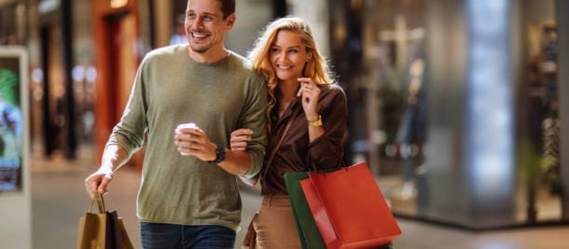 C'est un homme et une femme qui font les soldes, ils ont des sac à la main