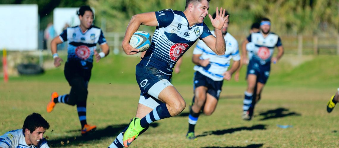 Image de rugbyman qui court dans l'herbe. C'est un club sportif